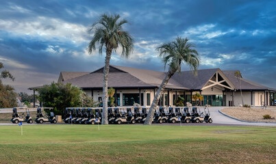 Multiple golf carts parked  outside clubhouse