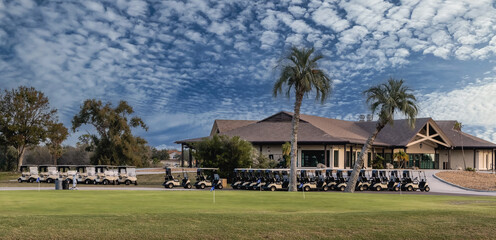 Multiple golf carts parked  outside clubhouse