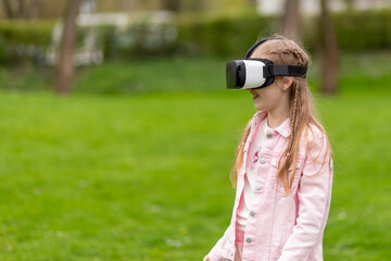 Girl in pink jacket using VR headset in park