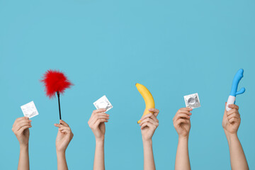 Female hands with sex toys, condoms and banana on color background