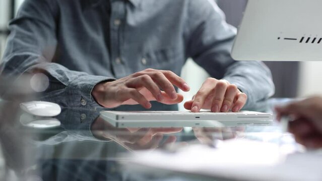 Working with a computer and documents at a desk in close-up in the office