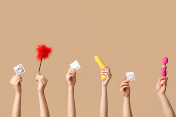 Female hands with condoms, sex toys and banana on color background
