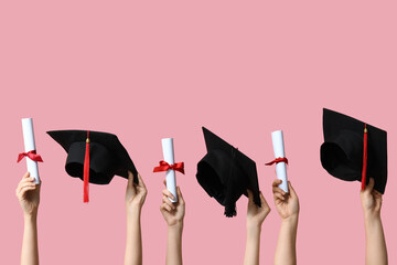 Female hands with graduation hats and diplomas on pink background