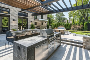 Obraz premium Contemporary outdoor kitchen with stainless steel appliances, stylish patio furniture, and a landscaped garden backdrop at a suburban residence