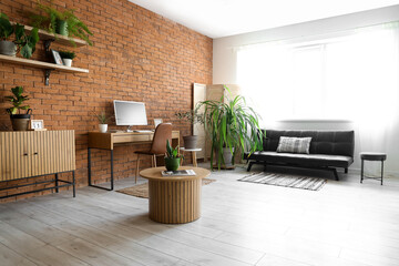 Interior of office with modern workplace, sofa and green houseplants