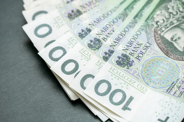 Close-up of Polish 100 Zloty Banknotes Arranged in a Row Against a Dark Background