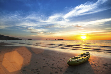 Tranquil beach sunset with canoe