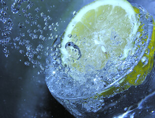 Fresh lemon slice plunged in sparkling water