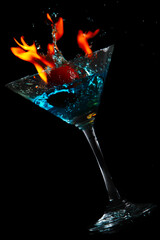Flaming cocktail splash on black background