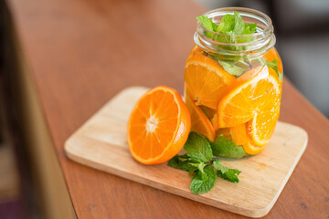 Fresh orange slices in a jar with mint