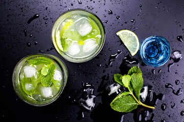 Fresh mojito cocktails with ice on dark background