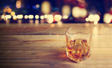 Whiskey glass on bar counter with blurred background