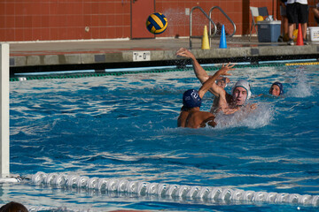 High School water polo player shooting the ball.