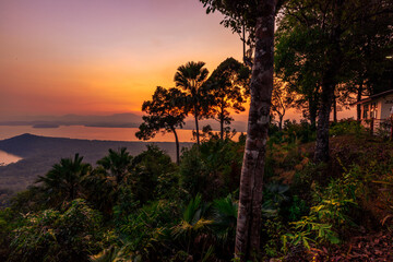 The close-up natural background of green rice fields, behind a large mountain and mist flowing through the blurred foliage, is a natural beauty seen in the countryside