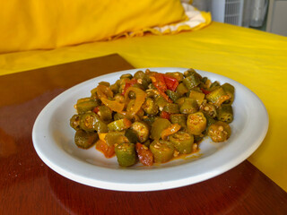 Delicious cooked okra with tomato sauce served on a porcelain plate