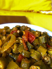 Delicious cooked okra with tomato sauce served on a porcelain plate