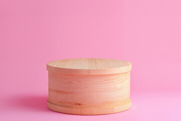 Wooden cylinder podium for cosmetic products on a pink background. High quality photo