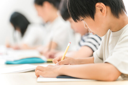 塾・学校の授業中にノートに記入する男の子・小学生の男女
