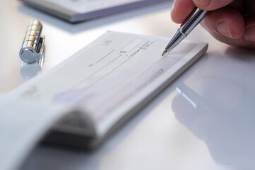 Close-up of hand writing a check
