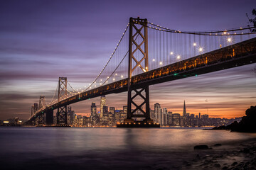 Twilight cityscape with iconic suspension bridge