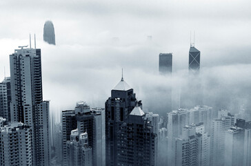 High-rise buildings towering over the city amidst a thick foggy atmosphere