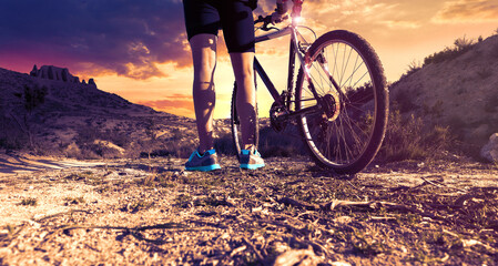 Cyclist at sunset on mountain trail