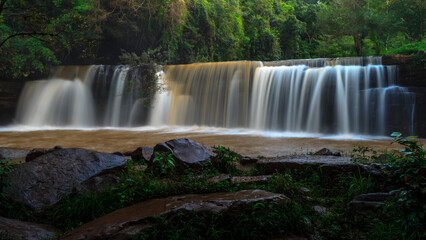Long exposure of a tranquil waterfall surrounded by lush greenery