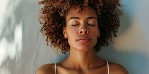 The woman closes her eyes again and takes a few deep breaths. She focuses on the feeling of the air entering and leaving her lungs. She feels her mind clearing and her body relaxing.