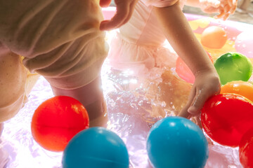 Children are playing in a pool with lots of colorful balls