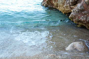 岩場のそばに打ち寄せる波とビーチ