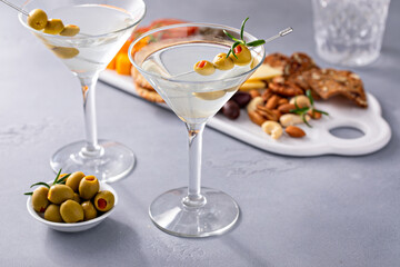 Traditional martini cocktail with olive garnish and charcuterie board - Powered by Adobe