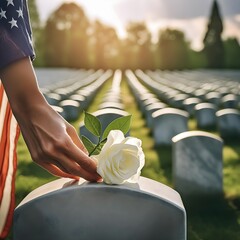 Una persona colocando una rosa blanca sobre una lapida