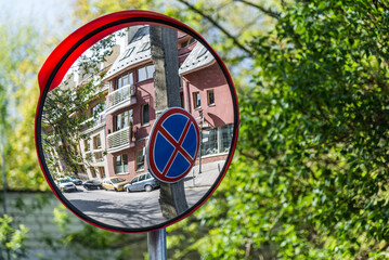 No Stopping Sign Reflected In Street Mirror Pole On Green Trees Background
