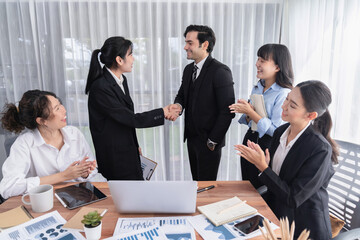 Group of businesspeople shake hand after made successful business agreement meeting. Diverse race...