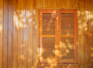 Brown Wooden shutters on a wooden wall background.