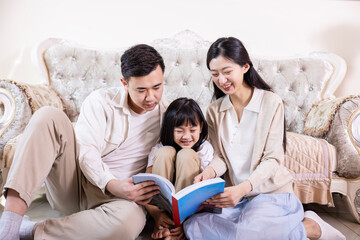 A family of three playing and reading in the living room
