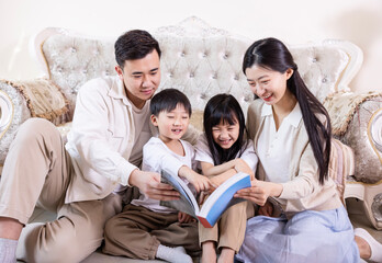 A family of four reading and playing together in the living room