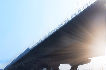 Elevated expressway during a sunny day . highway overpass against blue sky with sun