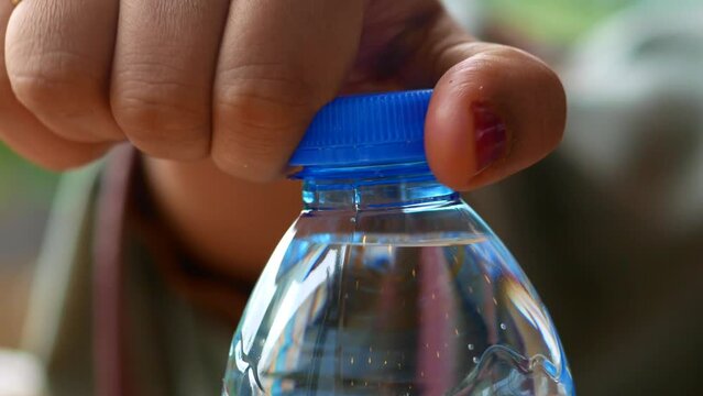 open a cap of a plastic water bottle 