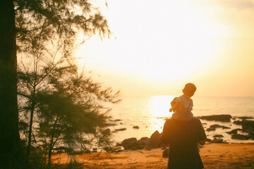 A dad and his sun under the sunset on Phu Quoc island, Vietnam