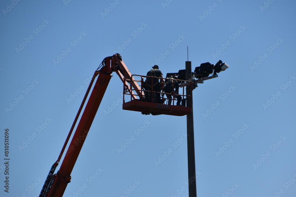 Wall mural two men changing lights on a sky lift