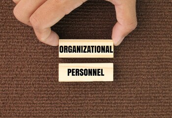 hand holding a stick with the words organizational and personnel. two types of performance...