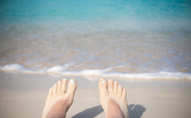 Feet in a white sand beach