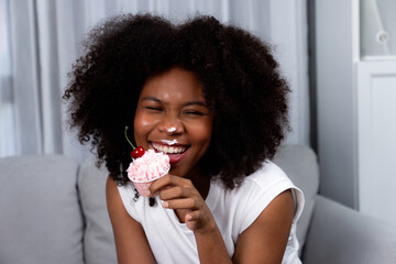 Funny beautiful young African blogger on mess face presenting cupcake in concept special cuisine....