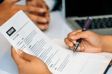 Human resources department manager reads CV resume document of an employee candidate at interview...