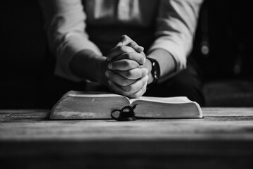 Hands Praying on Bible