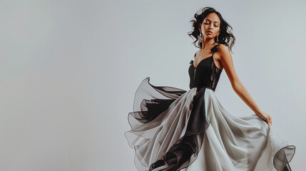 A successful woman exudes confidence in an elegant and expensive dress, commanding attention with her poised demeanor. She stands against a pristine white studio background.

