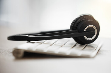 Headphones, keyboard and call center with equipment on desk for customer service, support or...