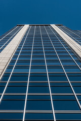 Low view of a facade of an office building with sky.