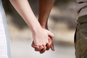 Interracial couple, holding hands and nature with love for care, support or companionship. Closeup...